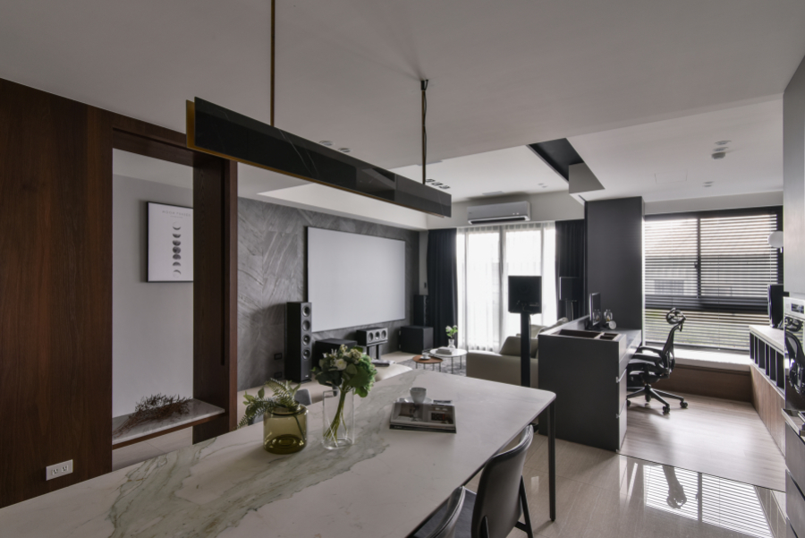 空間保留天花板白色,其他部分以灰黑色深色調為主,廚具選擇稍暖色調的門片,搭配顏色較淺的家具,讓整體空間達到視覺平衡,且不過於沉重
