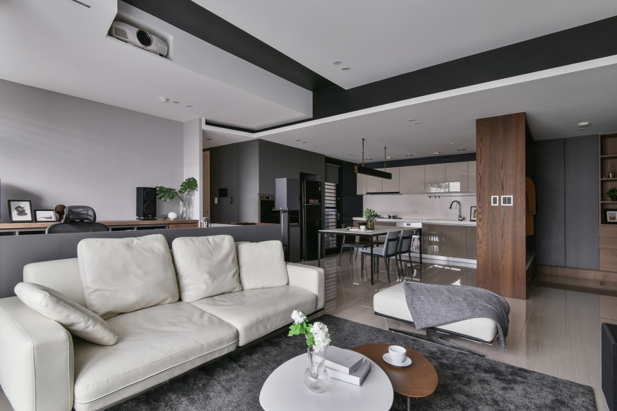 空間保留天花板白色,其他部分以灰黑色深色調為主,廚具選擇稍暖色調的門片,搭配顏色較淺的家具,讓整體空間達到視覺平衡,且不過於沉重