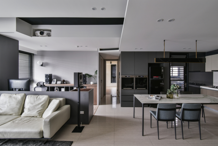空間保留天花板白色,其他部分以灰黑色深色調為主,廚具選擇稍暖色調的門片,搭配顏色較淺的家具,讓整體空間達到視覺平衡,且不過於沉重