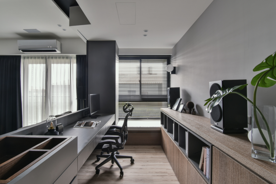 空間保留天花板白色,其他部分以灰黑色深色調為主,搭配不同色調的櫃體,使空間視覺不會感到疲乏