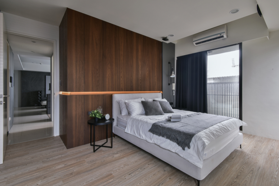 空間以灰黑色深色調為主,在門片與地板則使用了淺色系,讓空間不顯得昏暗、壓抑,加上床頭造型內藏燈光,也讓人有眼睛一亮的感覺