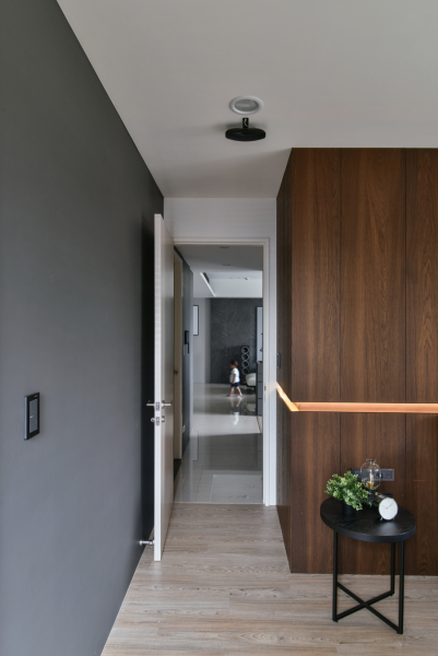 空間以灰黑色深色調為主,在門片與地板則使用了淺色系,讓空間不顯得昏暗、壓抑,加上床頭造型內藏燈光,也讓人有眼睛一亮的感覺