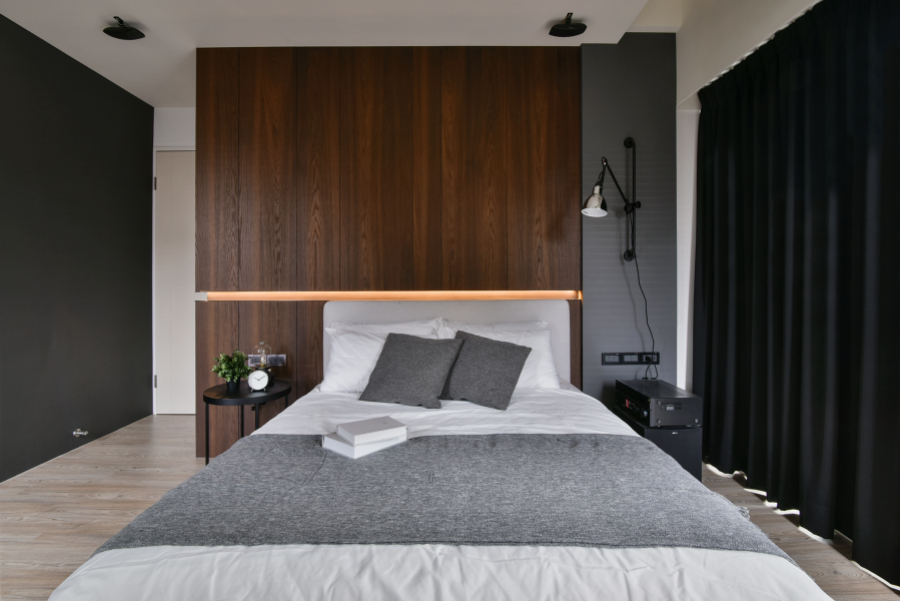 空間以灰黑色深色調為主,在門片與地板則使用了淺色系,讓空間不顯得昏暗、壓抑,加上床頭造型內藏燈光,也讓人有眼睛一亮的感覺