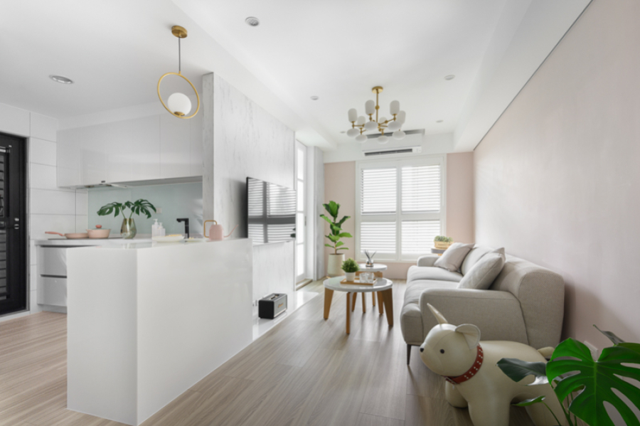 以白色為主搭配牆面跳色及暖色調的家具,呈現空間的溫馨感,在客廳與廚房之間做了中島及電器櫃設計,增加空間的使用性及便利性,同時也能讓視覺延伸、穿透,讓整體視覺空間更放大、不覺擁擠