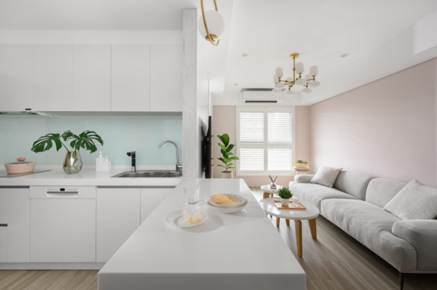 以白色為主搭配牆面跳色及暖色調的家具,呈現空間的溫馨感,在客廳與廚房之間做了中島及電器櫃設計,增加空間的使用性及便利性,同時也能讓視覺延伸、穿透,讓整體視覺空間更放大、不覺擁擠