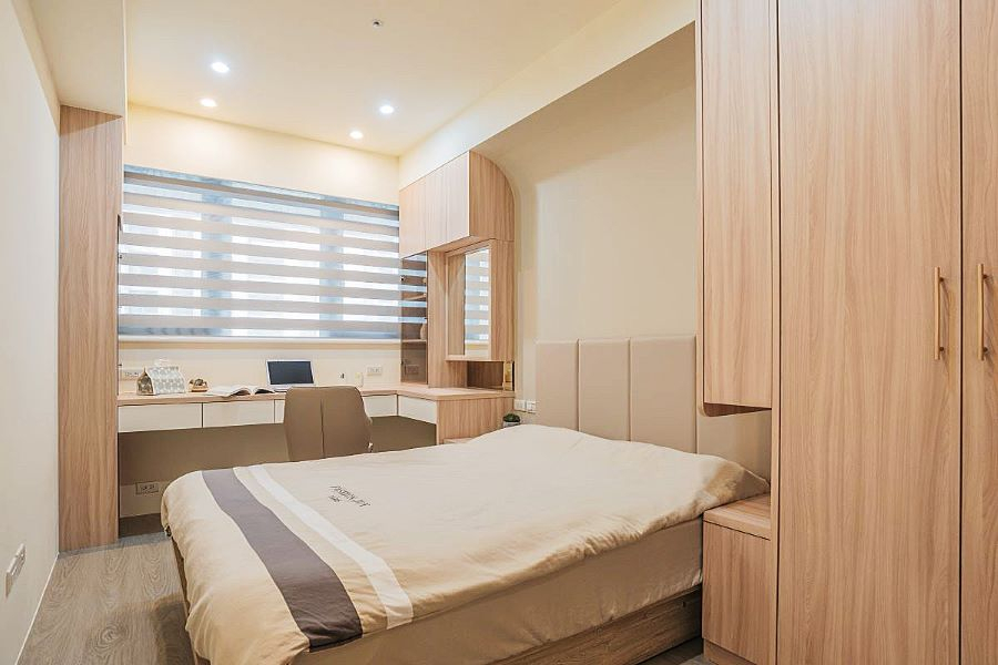 淨白的空間搭配暖色調的木紋,床頭以圓弧取代了直角,帶入了中性色作為空間主角,呈現較沉靜的空間