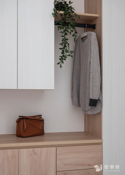 空間整體以白色和淺色木紋為主，規劃平台及鐵件吊衣桿方便吊掛外出衣物，增加進出時的便利性