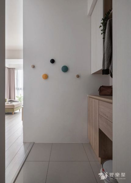 空間整體以白色和淺色木紋為主，搭配顏色較鮮艷的吊掛物件，增添空間的趣味性