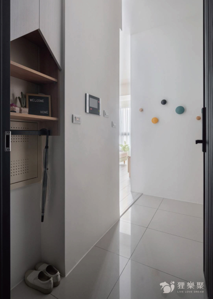 空間整體以白色和淺色木紋為主，搭配顏色較鮮艷的吊掛物件，增添空間的趣味，畸零空間規劃平台及鐵件吊桿可吊掛雨傘等小物件，增加空間的使用範圍