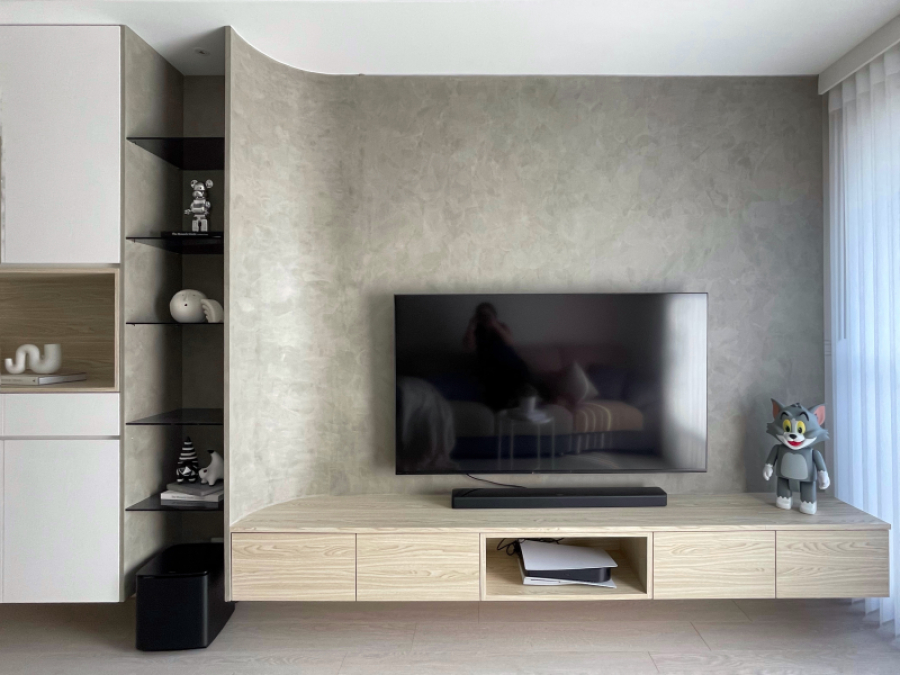 在天花板與電視牆中融入圓弧造型,電視牆面採用較有個性的灰色塗料,在溫暖的空間點綴視覺主角,使整體色調更加柔和