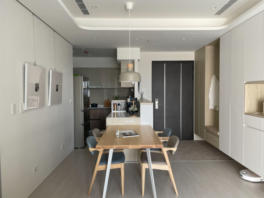 整體空間以白色搭配暖色系木紋,在設計上顧及了使用性,規劃為開放式中島,檯面上的收納設計,可收納小家電等物品,讓空間的視線範圍更為清爽整潔,同時也可作為備餐使用