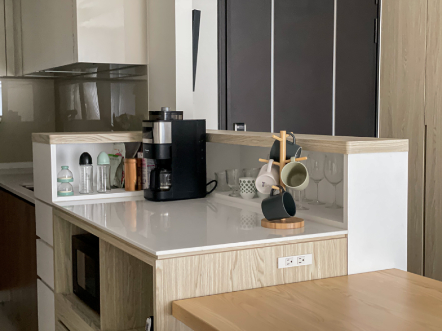 整體空間以白色搭配暖色系木紋,在設計上顧及了使用性,規劃為開放式中島,檯面上的收納設計,可收納小家電等物品,讓空間的視線範圍更為清爽整潔,同時也可作為備餐使用