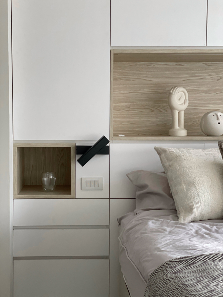 空間以白色搭配暖色木紋為主,床頭收納櫃做切割設計,在視覺上感受達到平衡