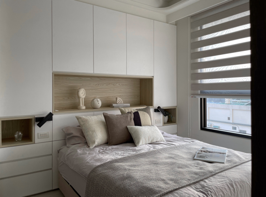 空間以白色搭配暖色木紋為主,床頭收納櫃做切割設計,在視覺上感受達到平衡