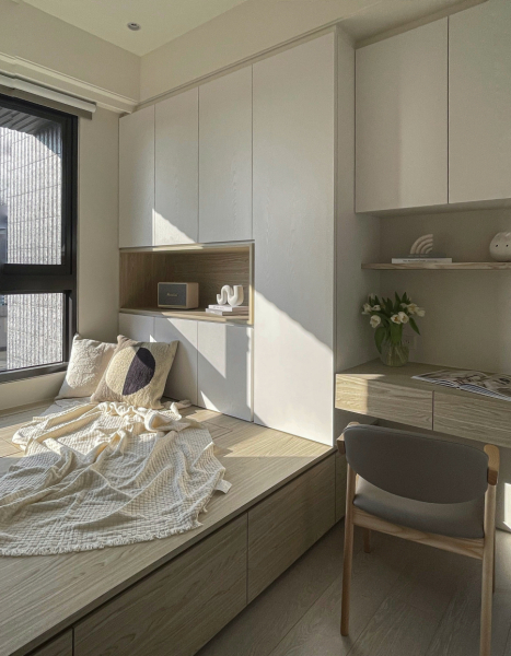 牆面大面積留白不特別跳色,搭配暖色系木紋,呈現空間沉靜感,臥榻設計可收納物品,同時也方便留宿的客人使用