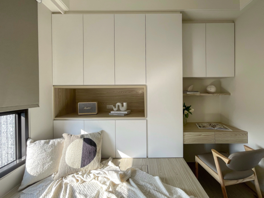 牆面大面積留白不特別跳色,搭配暖色系木紋,呈現空間沉靜感,臥榻設計可收納物品,同時也方便留宿的客人使用