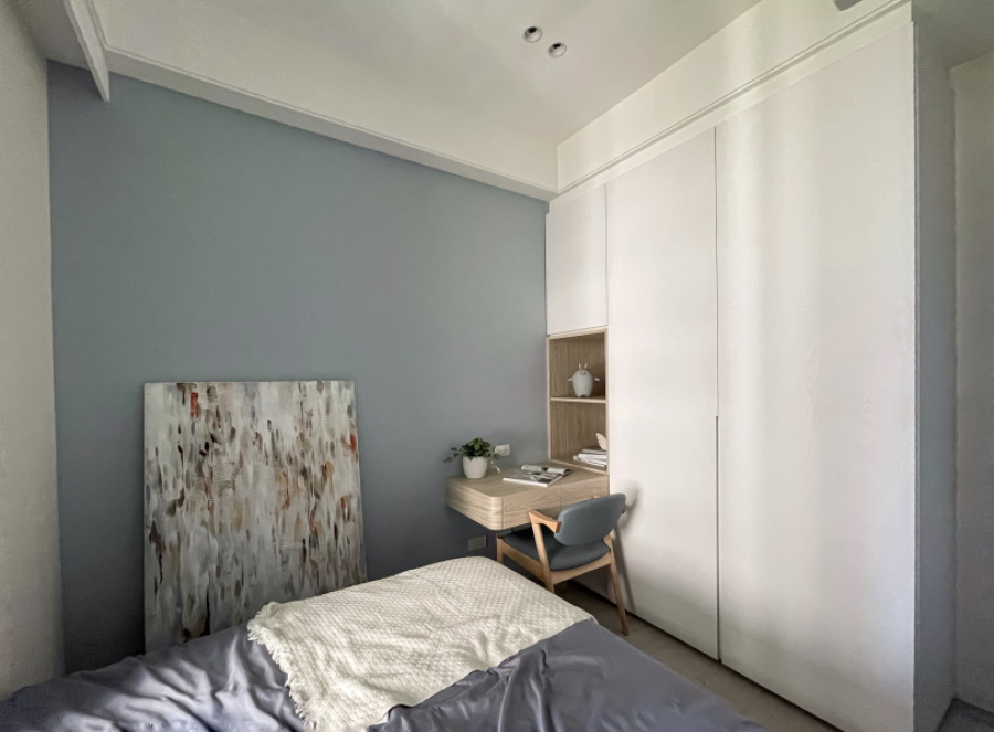 整體色系採用灰藍色為主題,搭配白色及暖色木紋系統櫃,讓整體空間簡潔俐落,書桌邊緣做了圓角設計,防止碰撞的同時也增添空間的柔和感