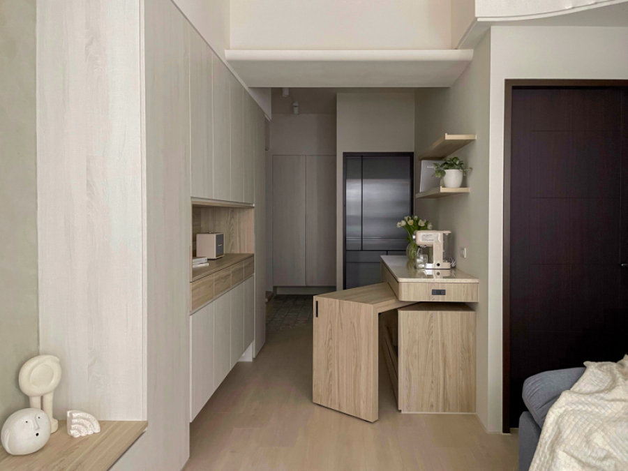 空間整體以淺色木紋為主,在餐廳設置電器櫃結合旋轉餐桌,將收納及機能結合為複合功能,因應不同使用情境設計靈活運用空間