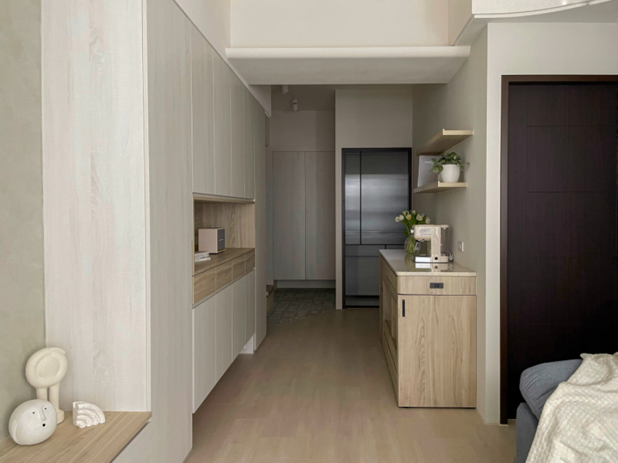 空間整體以淺色木紋為主,在餐廳設置電器櫃結合旋轉餐桌,將收納及機能結合為複合功能,因應不同使用情境設計靈活運用空間