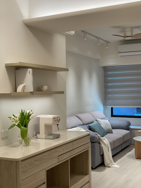 空間整體以暖色木紋為主,搭配電視牆低飽和度的灰色塗料,使整體空間帶有天然材質且明亮