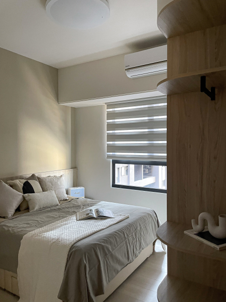 空間整體以白色及淺色木紋為主,入門採用開放式弧形設計,使得櫃體在空間感上不壓迫,搭配床頭跳色增添空間的溫柔感