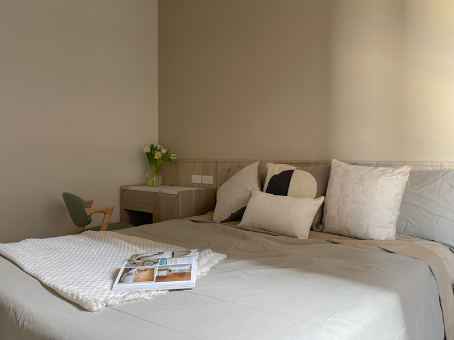 空間整體以白色及淺色木紋為主,入門採用開放式弧形設計,使得櫃體在空間感上不壓迫,搭配床頭跳色增添空間的溫柔感