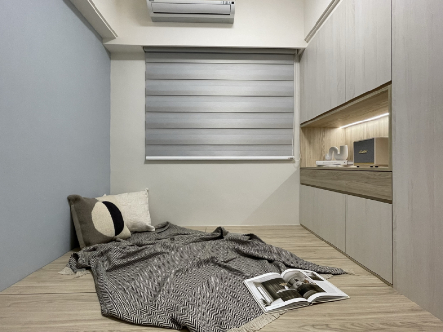 空間整體以白色及暖色調木紋為主,設計臥榻兼具收納及待客使用,搭配牆面中性色跳色增加空間的穩重性